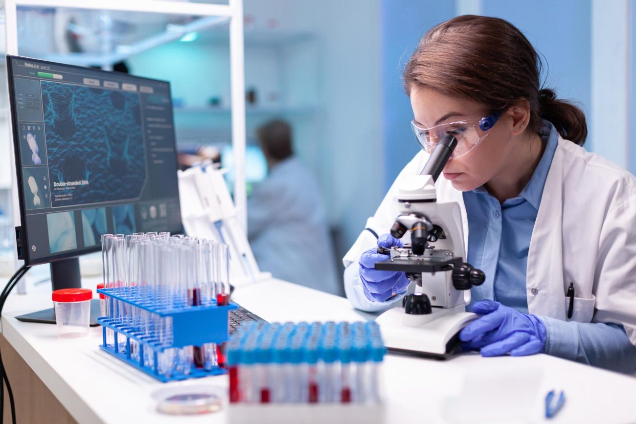 Laboratory scientist testing samples under a microscope